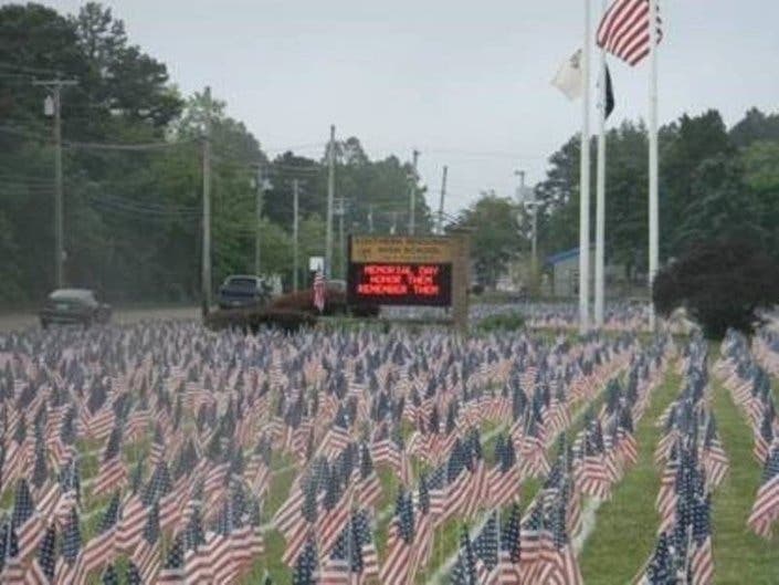 Students and ROTC cadets placed flags on the high school front lawn Thursday before Friday's Memorial Day ceremony.