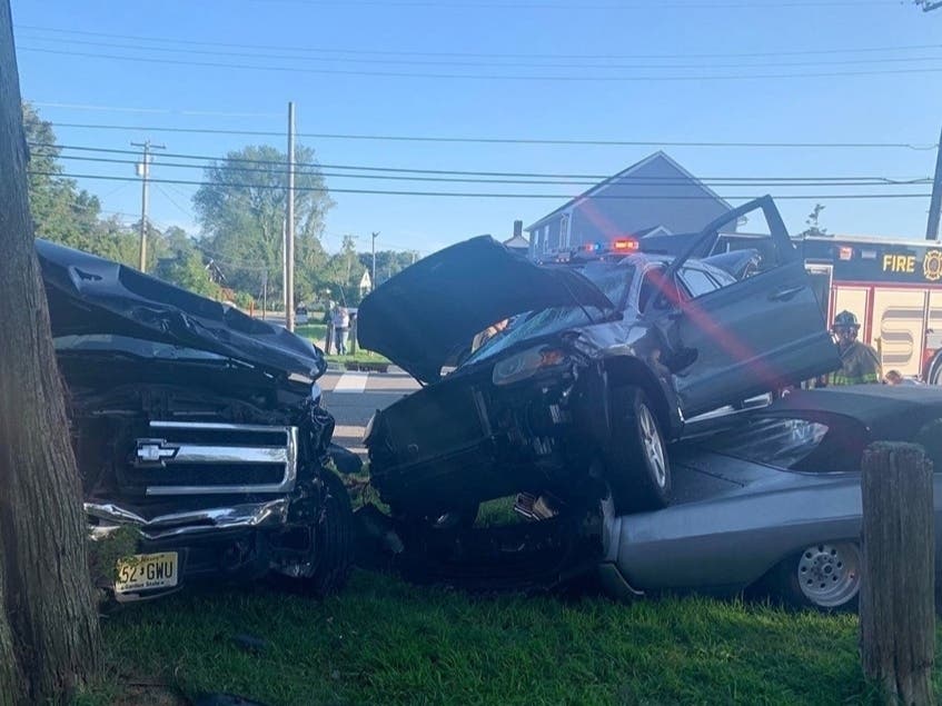 A woman was flown to the hospital after after her car was hit and it landed atop a parked vehicle, police said.