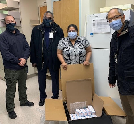 VA Police Detective Brandon Cruz, Lyons Associate Director John Griffith, Chief of Pharmacy Ann Verghese and pharmacist Jiang Li open the initial shipment of Moderna vaccines.