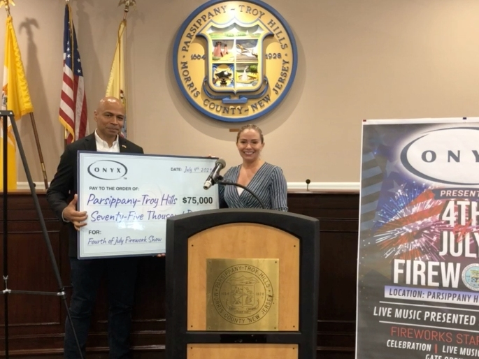 Mayor Michael Soriano stands with the giant check to show Onyx Equities's donation to Parsippany's Fourth of July celebration.
