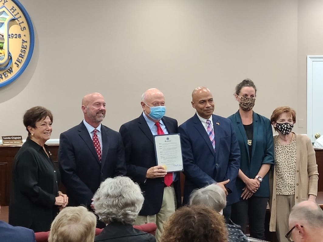 Mayor Michael Soriano, third from right, and members of Parsippany Township Council give a proclamation to Howard Letts, third from left, before a plaque dedication to his wife, former Mayor Mimi Letts.