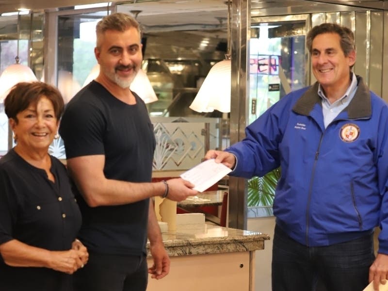 Morris County Commissioner Stephen Shaw, right, and Parsippany Township Council Vice President Loretta Gragnani deliver a grant to Frank Shizas at the Empire Diner.