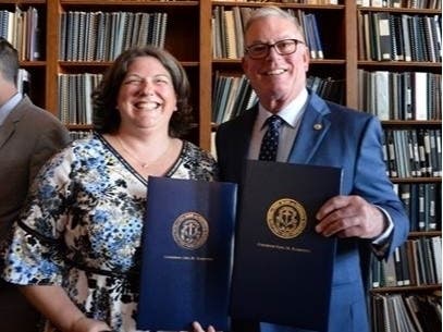 Senator Dawn Euer and Rep. Joseph McNamara hold ceremonial copies of the Student Loan Bill of Rights. 