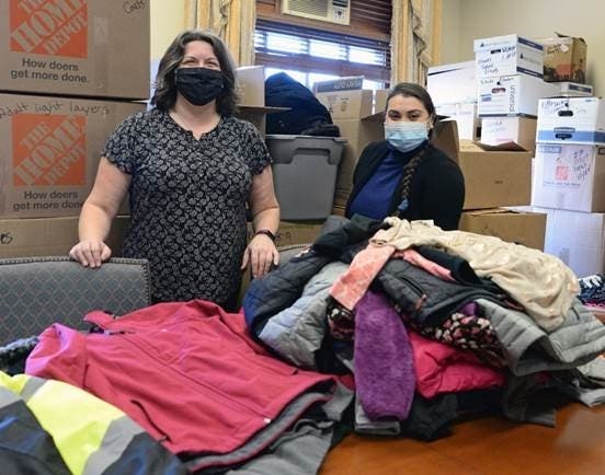 Sen. Dawn Euer (D-Dist .13, Newport, Jamestown), left, and Sen. Sandra Cano (Dist. 8, Pawtucket) sorting donations in a Senate hearing room packed with coats and winter gear donated by the public.