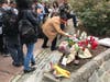 A man honors the victims at a memorial Monday morning at Kimlau Square.