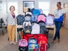 From left:  Faith Douglass, UWCFC Director of Development, delivers backpacks to Lourdes Duarte-Daluz, Resident Services Coordinator, Building Neighborhoods Together 
