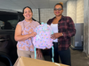 From left, Cristina Hernandez, ImageFIRST Human Resources Generalist, shares backpacks with Lourdes Duarte-Daluz, Resident Services Coordinator, Building Neighborhoods Together 
