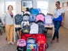 From left:  Faith Douglass, UWCFC Director of Development, delivers backpacks to Lourdes Duarte-Daluz, Resident Services Coordinator, Building Neighborhoods Together 