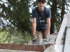 Young man helps to relocate bricks in preparation for a future retaining wall 