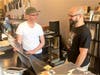 Village Vinyl & Hi-Fi owner Jonathan Sandler, right, and DJ Nick Branigan talk music behind the Brookline store counter.