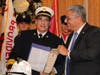 Chief Glenn Quick accepts his official fire chief helmet and certificate of promotion on Tuesday.