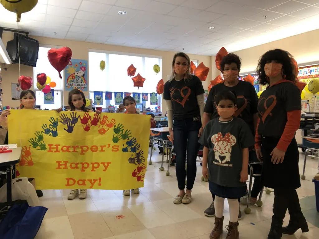 Brown Elementary teacher Elizabeth Ofilos, far right, students Natalie Billingsley, Keira O’Connell and Delanie Billingsley, and teachers Ingrid Hjerpe, Denise Lemenager help student Harper Reis, front right, celebrate her final cancer treatment Monday.