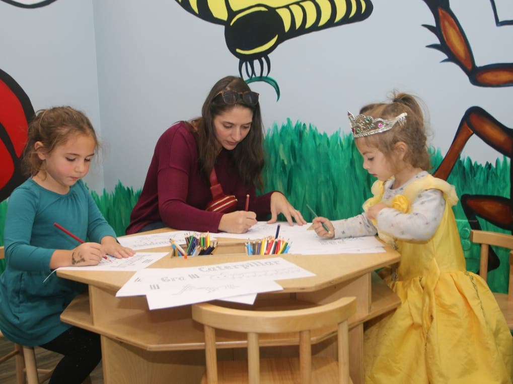 Alex Kistner, of Hamilton, works on a project with her two daughters in the "Bug Room" at the North Shore Children's Museum in Peabody.