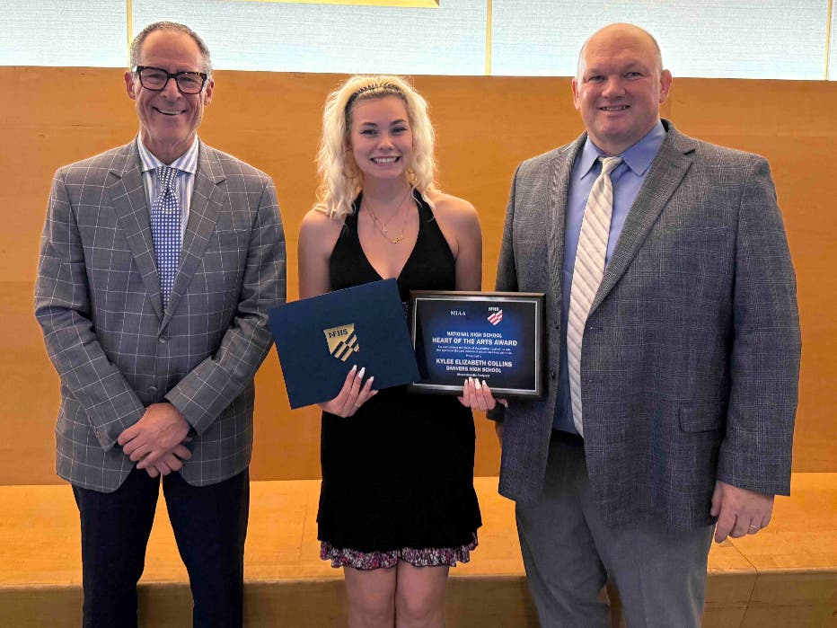 Danvers High Principal Alan Strauss and Superintendent Dan Bauer help present senior Kaylee Collins with this year's national Heart of the Arts award.