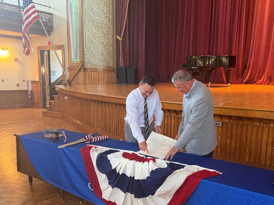 Peabody Mayor Ted Bettencourt and State Rep. Thomas Walsh (D-Peabody) unveil the replica of the Declaration of Independence that will be displayed in the Wiggin Auditorium.