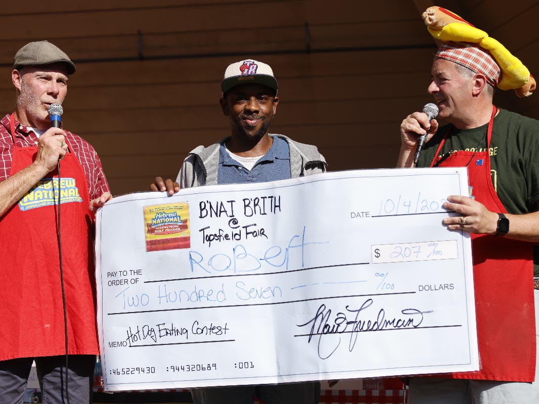 Robert McGee of Rockaway, New York, stands with the giant check he won at the 2025 Topsfield Fair Hot Dog Eating Contest. 