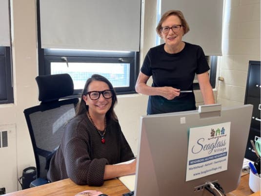 Executive Director Anne Quagrello (seated) and board member Claire Reagan in Seaglass Village’s new office space at the Clarke School. 