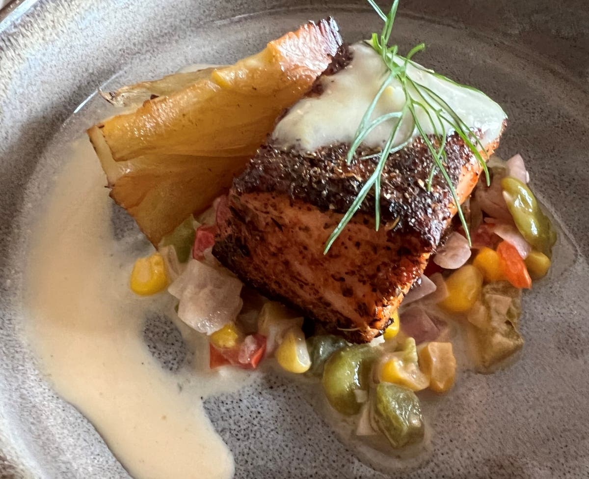 Blackened salmon is served with fava bean succotash, braised fennel and Florida citrus Buerre Blanc.
