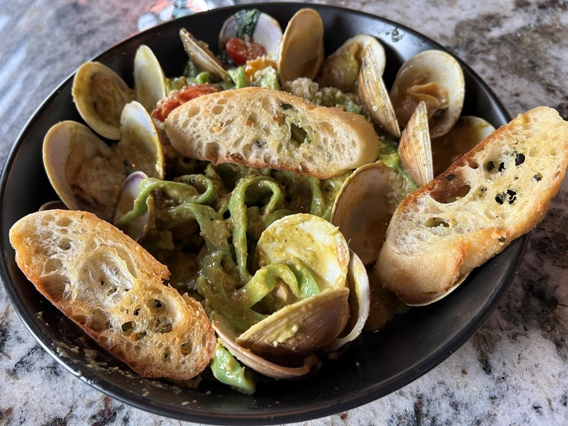 The seafood pasta contains shrimp, scallops, calamari, mussels and clams, tossed in a homemade spinach de fettuccini and creamy roasted poblano pepper sauce​.