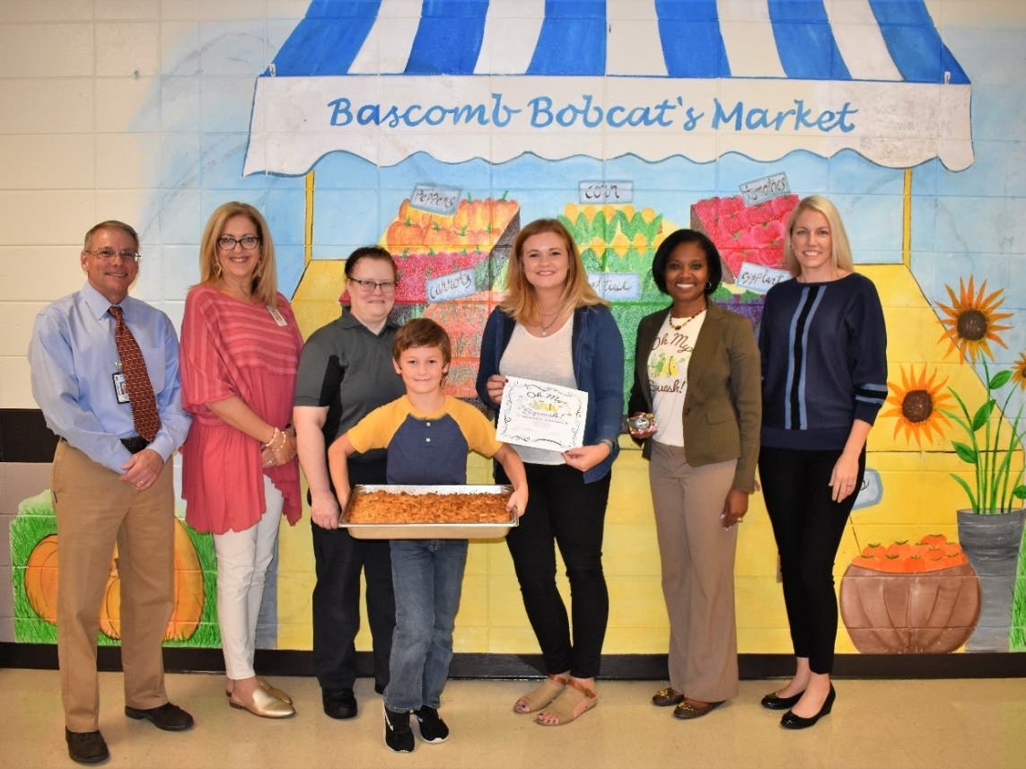 Jaydon Young, center, holds a dish of his mom, Christen Winkelman's, winning squash casserole dish. 