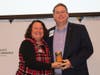 Lori Flink, owner of Allegro Business Products and Leadership Cherokee Class of 2017, presents the Golden Can Award for the most donations collected to Jason Blakey, Credit Union of Georgia,  Leadership Cherokee Class of 2019.