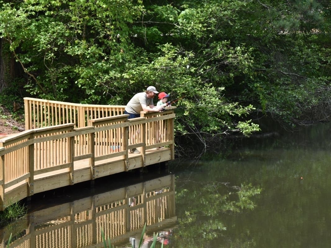 Chris Peterson and his son Elliot, 8, enjoy fishing on the new accessible kids' fishing pier built at the Island Ford unit of the Chattahoochee River National Recreation Area with funding from the Chattahoochee National Park Conservancy and donors.