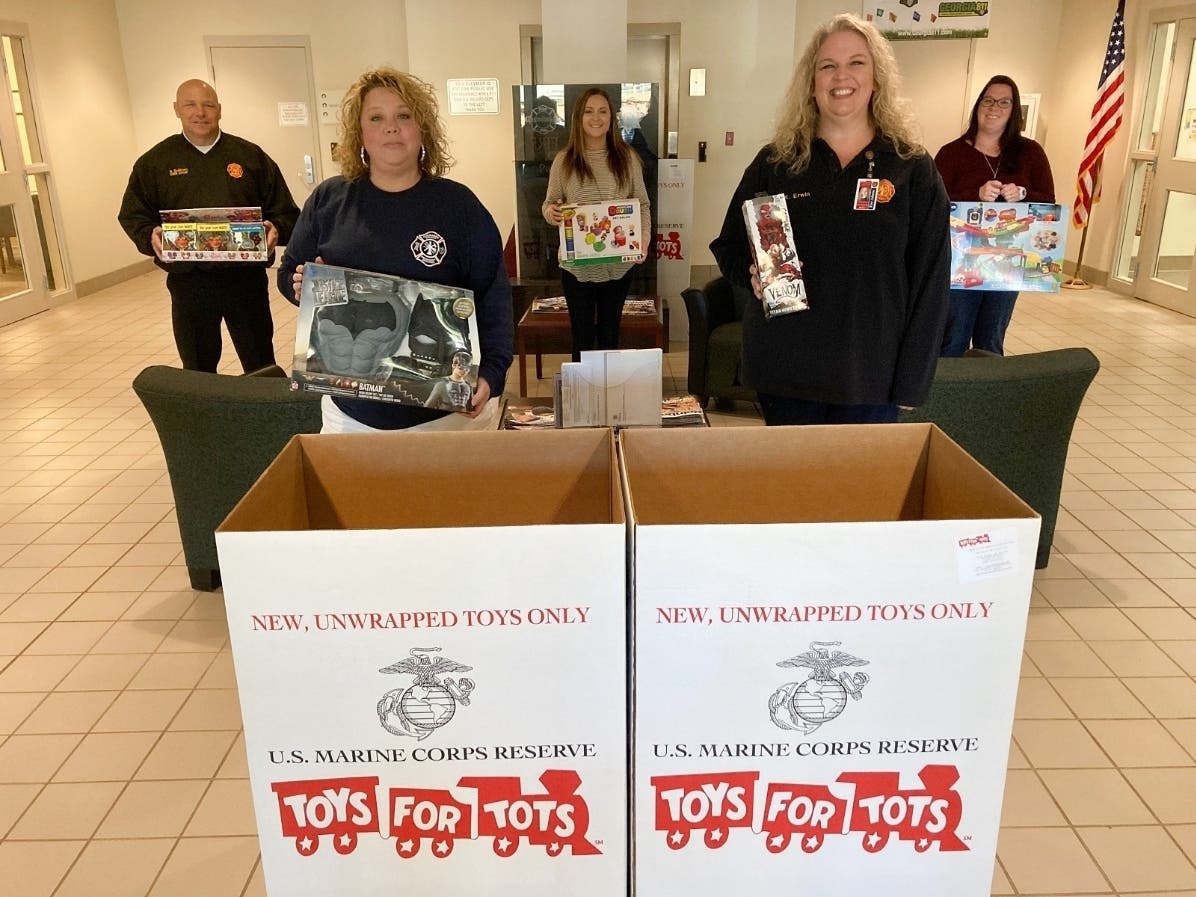 Employees with Cherokee County Fire and Emergency Services hold toys that have been donated for Toys for Tots.