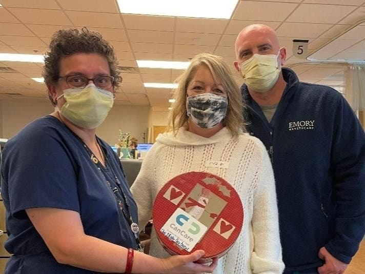 CanCare volunteer Brenda Hydrick, center, delivers cookies to nurse Jasmine Moomed and Randy Harrell, staff member at Winship Emory Johns Creek.