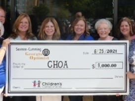 Laurie Cole, right, Children's Healthcare of Atlanta, accepts a check for $9,000 from Sawnee-Cumming Optimist Club golf tournament chairperson Brenda Basey, left, and other club members.