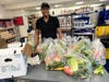 Hillside Food Outreach volunteer JayVon Downer prepares food packages for delivery to local neighbors in need.