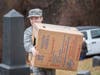 Cadet Airman Zac Conger carrying a box of wreaths to the top of the hill.
