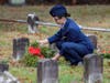 Cadet Technical Sergeant Erin Travers lays wreath on headstone.