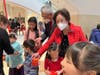E.D. Chih-Hsiang Li and his wife Dr. Chou-Chi Li are giving out red envelopes to children at the CCACC 2022 Lunar New Year Celebration at Westfield Montgomery Mall in Bethesda, MD.