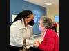 Dr. McGhee chatting with an elderly lady at CCACC Adult Day Healthcare Center, followed by warm hugs and embraces.