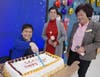 Ms. Rita Lewi, Executive Director of CCACC, cut the cake celebrating CCACC's 42nd anniversary. Middle of front row: Ms. Li-Fang C. Liu, Deputy Executive Director of CCACC; Right of front row: Ms. Jane Yang, Secretary of CCACC Board.