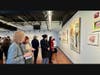 Viewers engaged in a vibrant conversation in front of the artworks, sharing their perspectives and thoughts.