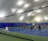 Indoor tennis courts featuring professional-grade surfaces and stable lighting.