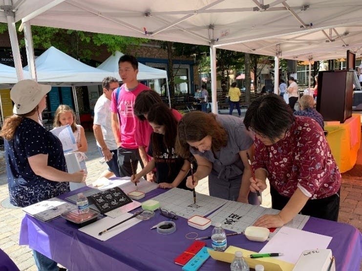 Community members taking interest in learning and trying Chinese calligraphy