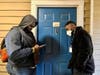 Everyday Canvassing Executive Director Mady Nadje (right) has been speaking to a community member through the door at the Rio Center in Gaithersburg for nearly 30 minutes while colleague Wesley Boateng (left) is taking the notes. 