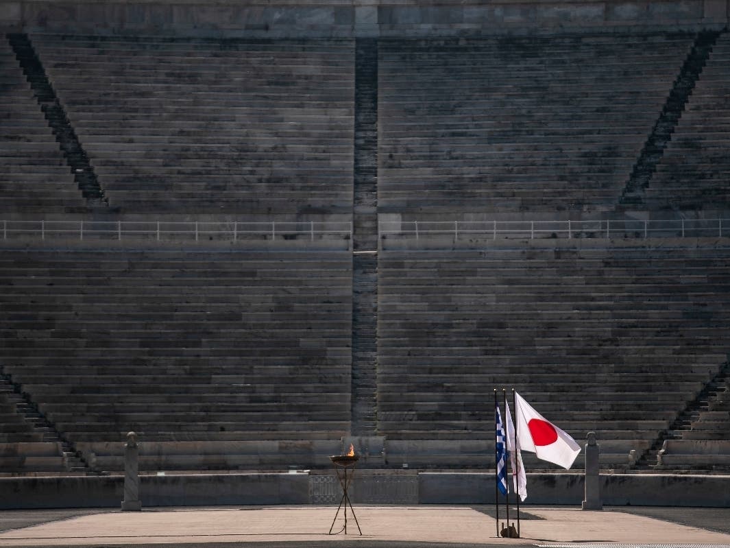 The Japanese flag flies next to an altar with the Olympic Flame of the Tokyo 2020 Olympic Games, inside the Panathenian stadium.