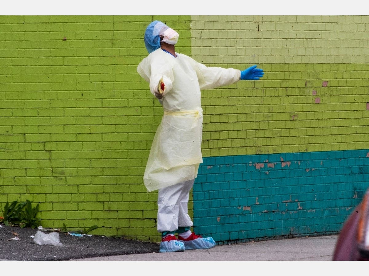 A medic of the Elmhurst Hospital Center medical team reacts after stepping outside of the emergency room, Saturday, April 4, 2020, in the Queens borough of New York.