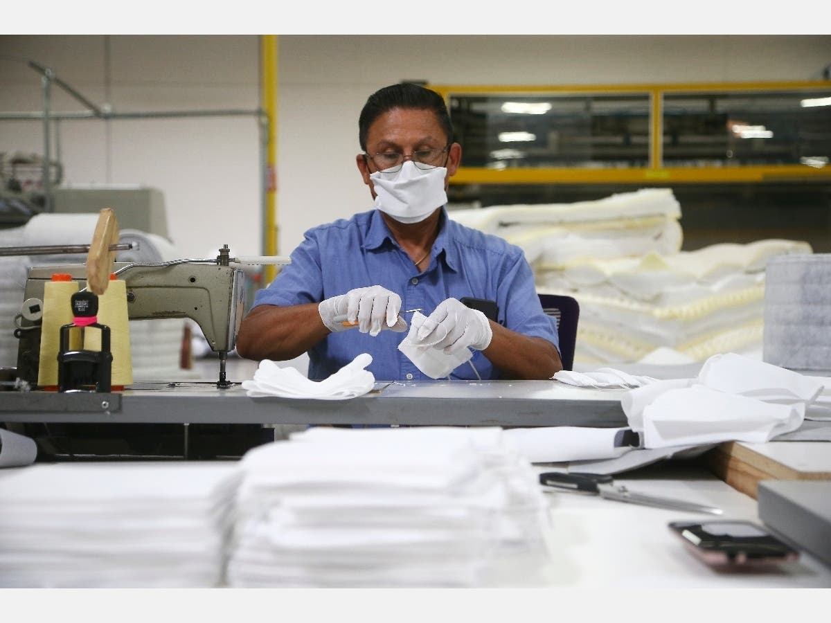 Jose Gonzalez works Monday to make non-N95 face masks, as the Ortho Mattress company in Phoenix is repurposing its factory to make the masks due to the coronavirus pandemic.