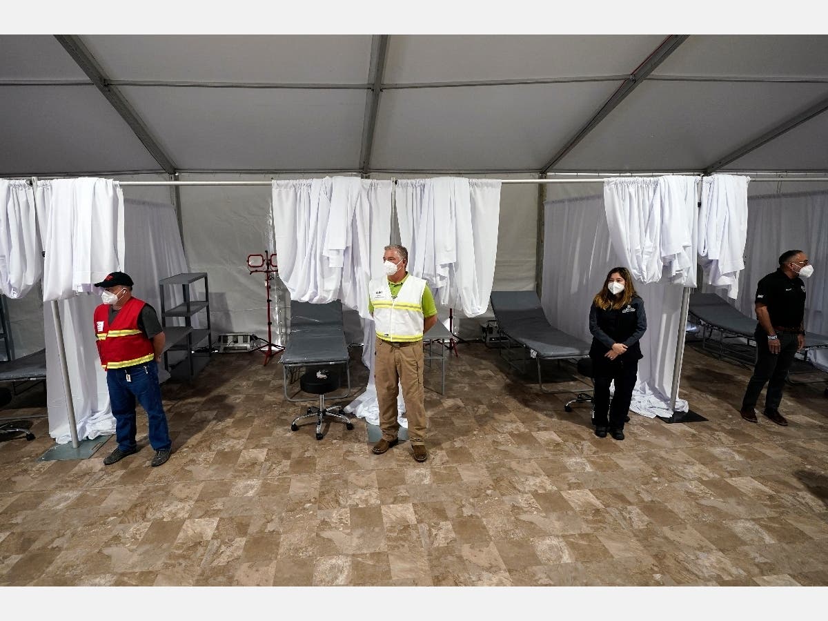 Medical professionals wait by empty beds during a tour of the new Harris County Non-Congregate Medical Shelter at NRG Park Saturday, April 11, 2020, in Houston.