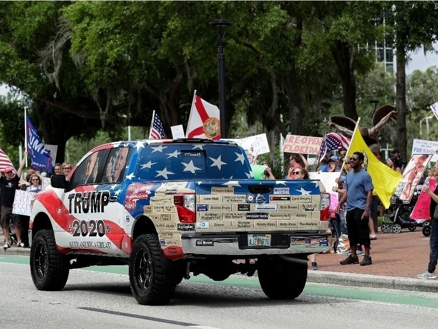 A truck supporting protesters demanding Florida businesses and government reopen, honks at a gathering in downtown Orlando, Florida.