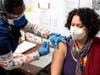 Lenora Clarke, LPN of Westchester Medical Center administers the milestone COVID-19 vaccine to Catalina Restrepo.