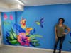 Artist Nancy Mendez with her mural in Curran Court Community Room 