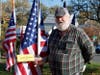 Navy veteran brother of Scott Baldwin who served in the US Army during the Vietnam War proudly stands with his brother's flag.