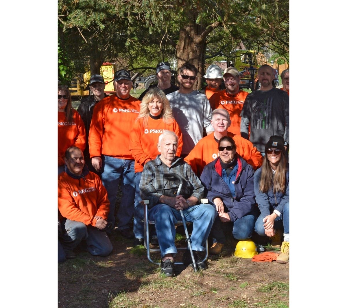 World War II vet Clem Novak got a visit and a yard cleanup from over 20 PSEG Long Island employees, including Coast Guard veteran Bart Polizzotti (left, in orange shirt and gray cap), of Sound Beach, and Navy veteran Kevin Rodgers (right, crouching).