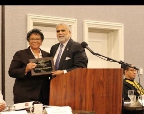 Pastor Charles A. Coverdale of the First Baptist Church of Riverhead (right) presents Suffolk County Deputy Police Commissioner Risco Mention-Lewis (left) with the Martin Luther King, Jr. Meritorious Award.