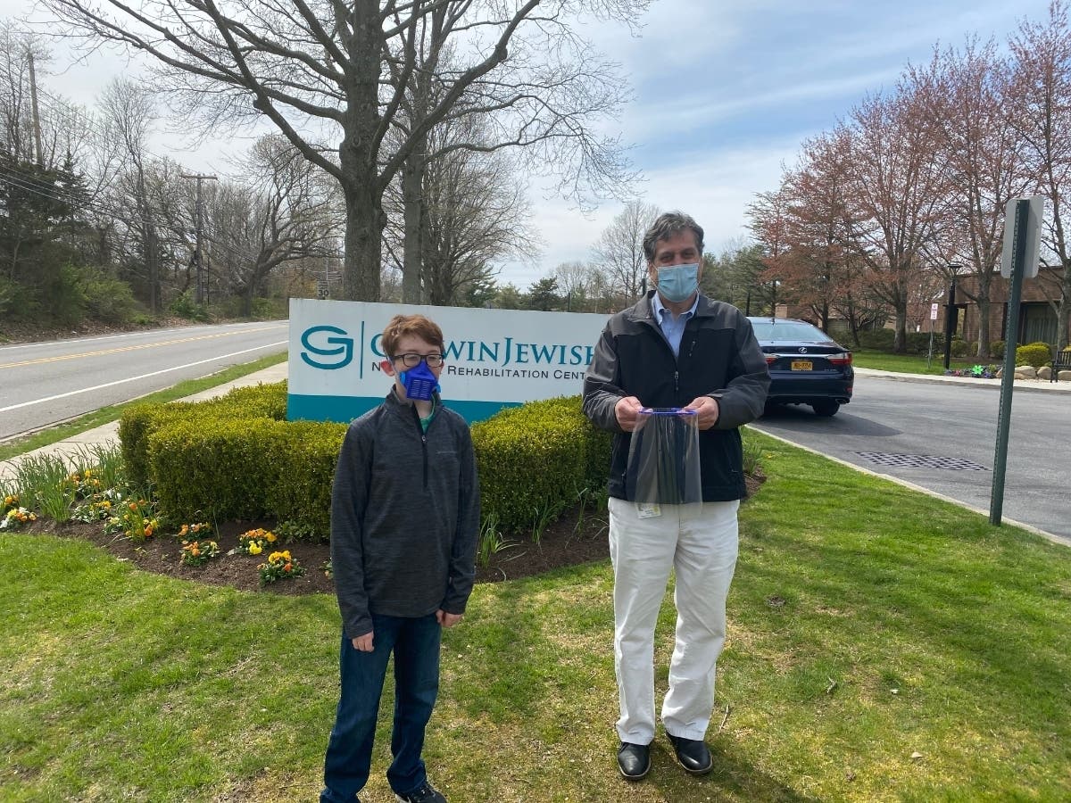 Nick Borruso (left) and Gurwin CEO Stu Almer with one of the face shields Nick made and donated to Gurwin Jewish Nursing & Rehabilitation Center in Commack.